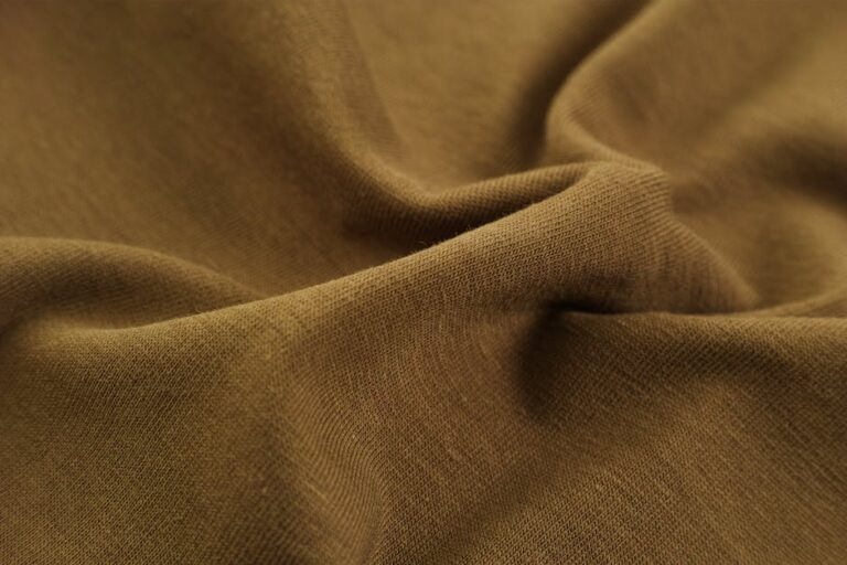 Detailed close-up view of brown fabric with visible folds, creases, and texture.