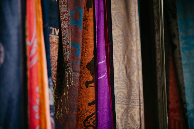 Colorful textiles on display at an indoor market stall in Nazareth, showcasing rich designs and textures.